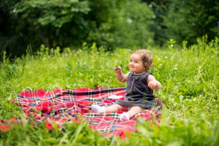 Bébé fille jouer dans la nature sur plaid couverture