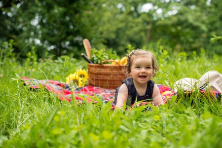 Bébé sur un pique-nique dans le parc, profiter dans l'herbe verte