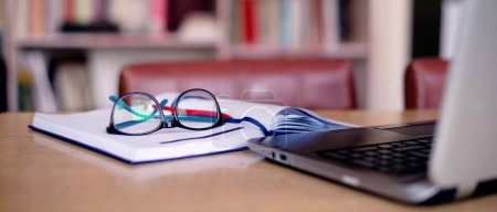 Photo for Office tools for school project: laptop, book, eyeglasses. - Royalty Free Image