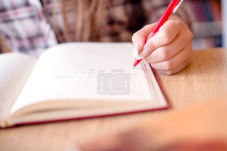 Cut out of students hand writting in notebook, preparing for exams.
