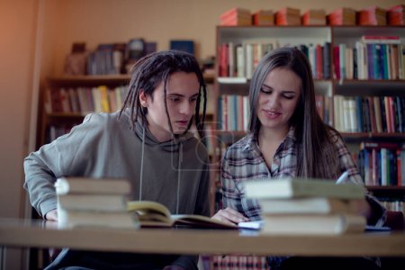 Zwei Studenten lernen gemeinsam in der Bibliothek, Frontansicht.