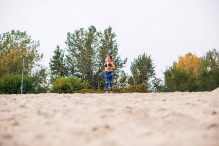 Photo for Young woman running on the beach, low angle view. - Royalty Free Image