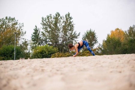 Photo for Young woman having fitness training on the beach, warming up. - Royalty Free Image