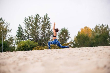 Photo for Woman doing stretching exercising outdoors, low angle view. - Royalty Free Image