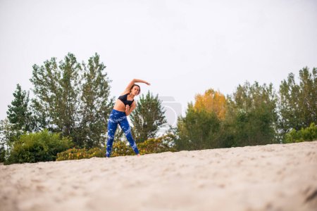 Photo for Young beautiful woman exercising in the nature. - Royalty Free Image