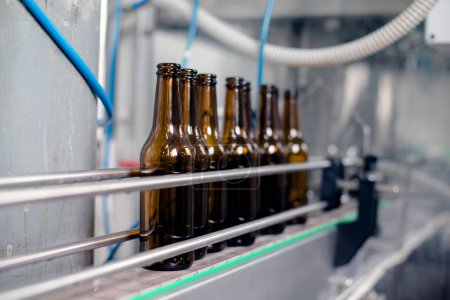 Primer plano de la línea de producción de botellas de cerveza.