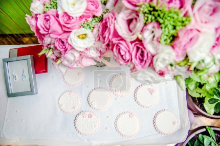 Blick auf den Hochzeitstisch mit Rosen, Geschenken und Kuchen.