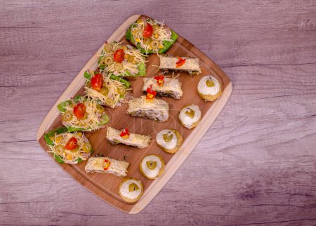 Nice decorated canapes on a wooden plate