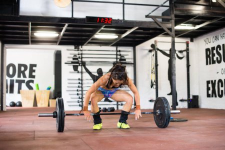 Téléchargez les photos : Femme forte soulevant des poids dans la salle de gym - en image libre de droit