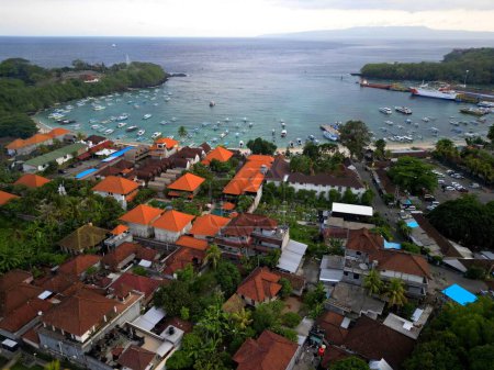 Filmación aérea de Padang Bai Village en Bali Indonesia. Pueblo Pescador. Casas Balinesas. Barcos estacionados en el puerto. .. Foto de alta calidad