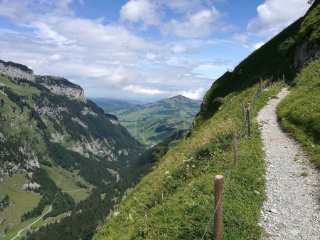 Dramatic Photo of Alpstein Hiking Path with clouds, mountains, switzerland, hiking season . High quality photo