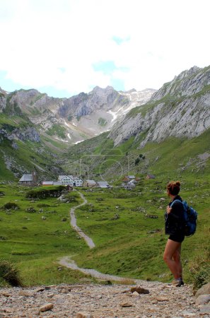 Hiking Women with backpack looking at Meglisalp in the alpstein, switzerland. Wanderlust. Appenzellerland. High quality photo