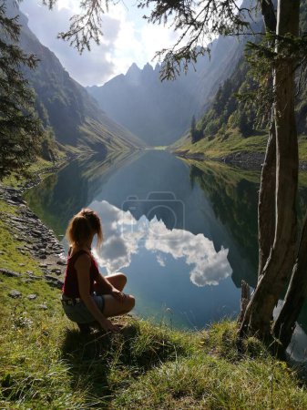Frauenwandern in den Schweizer Alpen, Appenzellerland, Alpstein, Silhouette mit Falensee im Hintergrund und wunderschöner Spiegelung von Bergen und Wolken. Hochwertiges Foto
