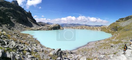 Wanderer beim Blick auf den Schottensee mit hellblauem Aquarell, alpine, Pizol-Wanderung 5-Seen Schweiz. Hochwertiges Foto