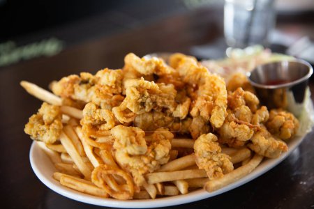 Téléchargez les photos : Calamars frits et frites servis avec sauce cocktail - en image libre de droit