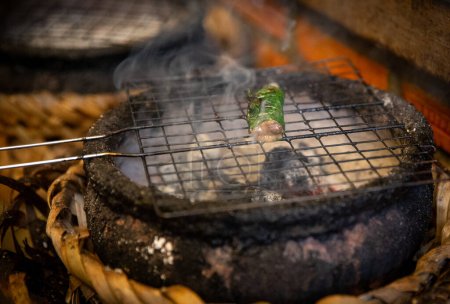 Grilling seafood in Asia over coals for an appetizer