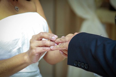 Téléchargez les photos : Bride plaçant une bague sur le marié lors de la cérémonie - en image libre de droit