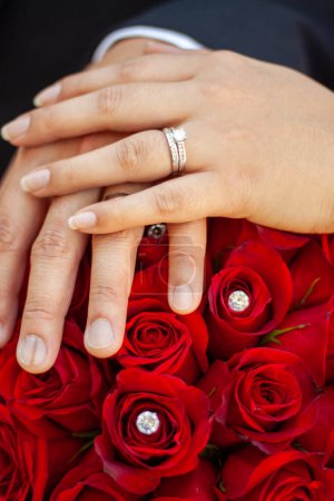 Foto de Manos de pareja recién casadas con rosas y diamantes - Imagen libre de derechos