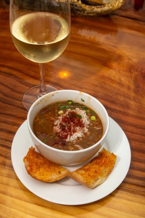 Cup of Creole Gumbo served with a glass of wine
