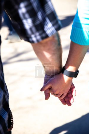 Lässiges Paar hält Händchen beim Gehen
