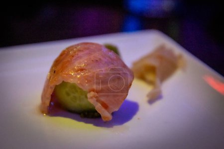 Seared Salmon Belly on top of a cucumber