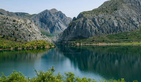 Téléchargez les photos : Vue panoramique sur les montagnes qui se reflètent sur un lac dans le nord de l'Espagne. Cadre paisible et tranquille avec ombres à travers les collines et les vallées. - en image libre de droit