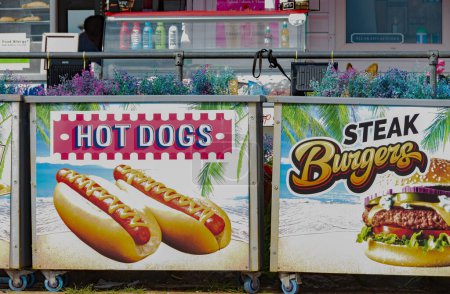 Téléchargez les photos : Paignton Royaume-Uni. 09-11-23. Hot dog et hamburger au bord de la mer. Affichage lumineux de signe d'image à l'avant de magasin. - en image libre de droit
