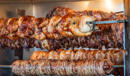 Téléchargez les photos : Spit rôtissant la viande rositere devant un restaurant. - en image libre de droit