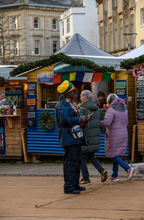 Téléchargez les photos : Exeter UK. 11-28-23. Acheteurs au marché de Noël d'Exeter. personnes marchant pendant le marché de Noël admirant étal de marché, acheter de la nourriture, des cadeaux et des jouets. décorations lumineuses pendant l'hiver. - en image libre de droit