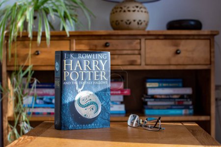 Foto de Exeter UK. 02-13-24. Harry Potter and the Deathly Hallows book by J.K. Rowling. Un adolescente leyó un libro de cuentos de magia y artes oscuras. espacio de copia. - Imagen libre de derechos
