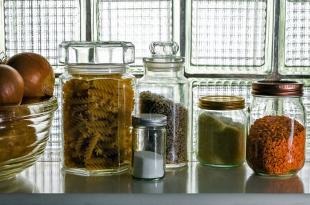 Grocery Food supplies placed in jars. Colourful selections of pasta,  seeds and lentils, a cooks essential store, pantry. A shelf of dried goods, ingredients. zero waste storage. 
