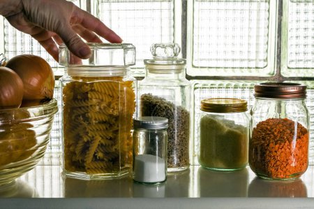 Grocery Food supplies placed in jars. Colourful selections of pasta,  seeds and lentils, a cooks essential store, pantry. A shelf of dried goods, ingredients. zero waste storage. 
