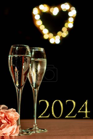 Photo for 2024 New year image with two glasses of frosted Champaign against a soft heart shaped light bokeh background. Selective focus on the left hand frosted glass. 2024 new year concept. Celebrate new year - Royalty Free Image