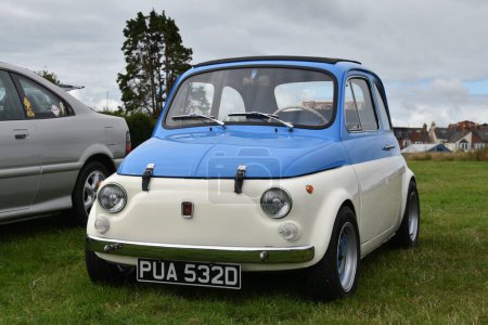 Photo for Exmouth, Devon, uk. 08-13-23. Fiat 500 classic car in blue and white. A gorgeous restored classic vehicle which is very popular at classic car shows. Selective focus on the front of the car. - Royalty Free Image