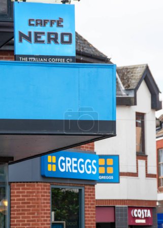 Photo for Exmouth, Devon, uk. 08-12-23. Cafe Nero, Greggs and Costa coffee signs on a high street. Selective focus on the Cafe Nero sign. Hot beverage and cafe image with copy space. - Royalty Free Image