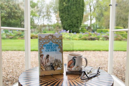 Photo for Ideford, Devon, uk. April 15th 2023. The Horse and his boy, by C S Lewis. The picture is set against a softly focused garden background. Selective focus on the front cover. Classic book - Royalty Free Image