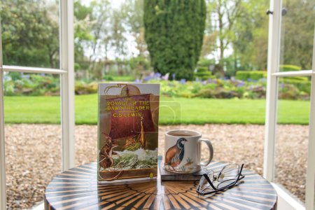 Photo for Ideford, Devon, uk. April 15th 2023. The voyage of the Dawntreader, by C S Lewis. The picture is set against a softly focused garden background. Selective focus on the front cover. Classic book - Royalty Free Image