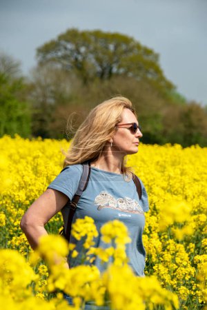 Photo for Newton St Cyres, Devon, uk. 04-29-23. Wildlife aid foundation charity T shirt being worn by a beautiful woman holding the palm of her hand up to the sun. Simon Cowell wildlife aid foundation. - Royalty Free Image
