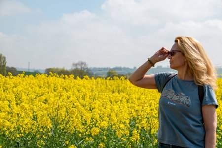 Photo for Newton St Cyres, Devon, uk. 04-29-23. Wildlife aid foundation charity T shirt being worn by a beautiful woman in a field of yellow rape seed. Simon Cowell wildlife aid foundation. - Royalty Free Image