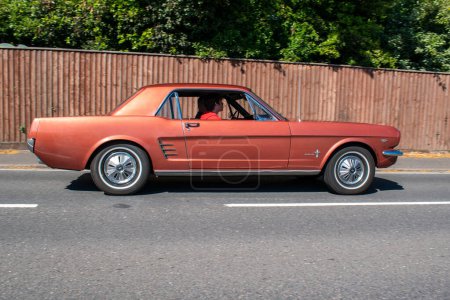 Foto de Powderham, Devon, Reino Unido. 9 de julio de 2022. 9 de 2022. Coche muscular Ford Mustang de 1960 en color Emberglo Metallic. Rara vez histórico V8 coche americano. Elegante, sexy, rápido y deseable. - Imagen libre de derechos