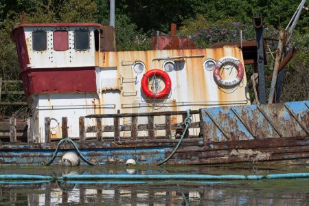 Téléchargez les photos : Exeter, Devon uk. 9 juillet 2022. Un bateau coulé rouillé avec des ponts en bois pourrissants dépeint une image de privation, de pourriture et d'échec. - en image libre de droit