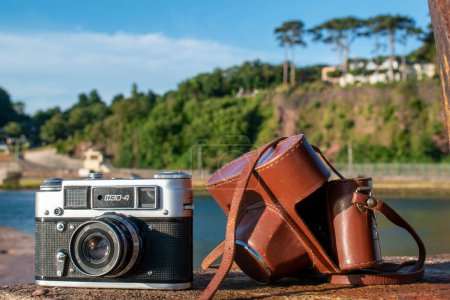 Photo for Teignmouth, Devon, UK. July 6th 2022. 35mm film camera with leather case at a seaside location. Sharp focus on the vintage Russian FED 4 Camera. Bright colorful editorial image. Retro photograpy - Royalty Free Image