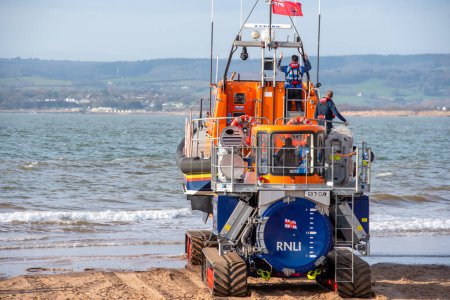 Photo for Exmouth, Devon, uk. 02-15-24. RNLI Lifeboat crew prepares to launch a Shannon class lifeboat from Exmouth lifeboat station. Sea safety life saving image. Copy space. - Royalty Free Image