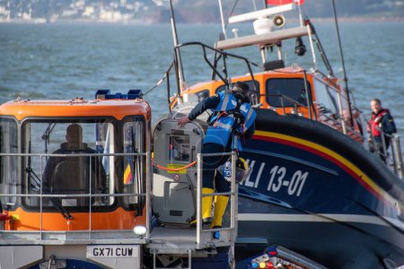 Photo for Exmouth, Devon, uk. 02-15-24. RNLI Lifeboat crew prepares to retrieve a Shannon class lifeboat at Exmouth lifeboat station. Sea safety life saving image. Copy space. - Royalty Free Image