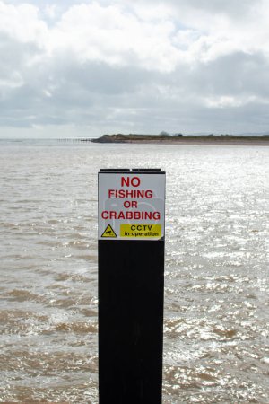 No fishing or crabbing sign with a sea view background