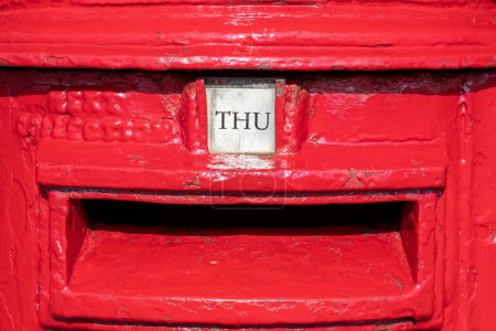 Donnerstag Wort als THU auf einem britischen roten Briefkasten gezeigt. Optisch auffälliges und farbenfrohes Bild im Querformat, das den Wochentag darstellt. Knallrot. Briefkasten und Postbild. 