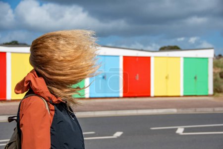 Foto de Una mujer con el pelo soplando en un día muy ventoso. Imagen meteorológica del clima extremo. - Imagen libre de derechos
