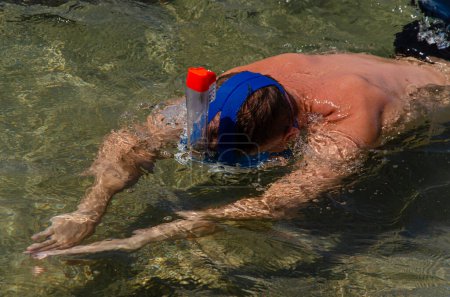 Téléchargez les photos : Nageur en apnée. homme plongée avec tuba dans la mer. Le nageur dans le cadre est positionné en diagonale. Arrière-plan : fond jaune-brun. - en image libre de droit