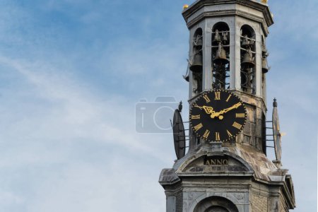 Munttoren Clock Tower, Amsterdam, contre un ciel bleu. Tour a une grande horloge face et une girouette au sommet. Arrière-plan, espace pour texte, espace de copie
