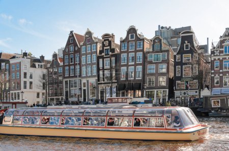 Photo for A pleasure boat in the foreground and canal houses in the background. Old Amsterdam. - Royalty Free Image